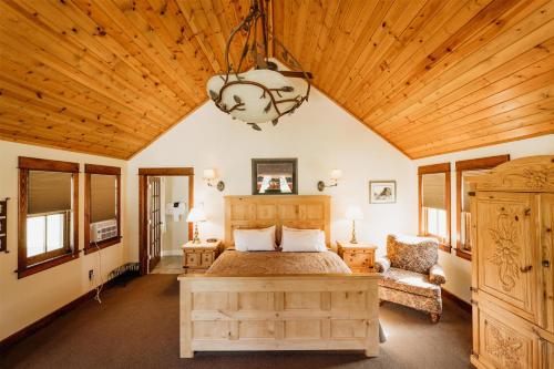 a bedroom with a bed and a wooden ceiling at Chico Hot Springs Resort in White City