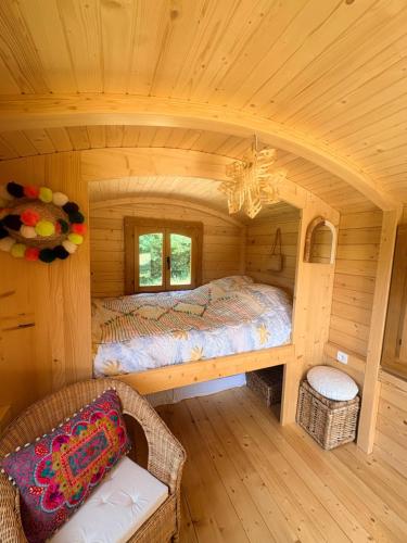 a bedroom with a bed in a log cabin at La roulotte de Clemence in Montfermy