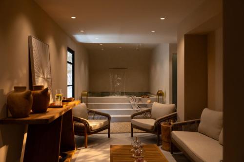 a living room with a tub in the background at Aetheria Boutique Hotel & Spa in Markopoulo