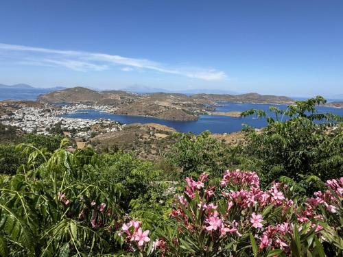 a view of a city and a bay with pink flowers at Chora Heritage Residence by Belle-Stay in Patmos