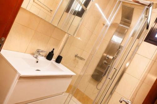 a bathroom with a sink and a shower at Olive Garden Vila in Karianí