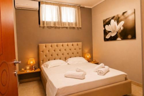 a bedroom with a bed with towels on it at Olive Garden Vila in Karianí