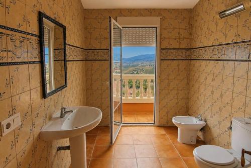 a bathroom with a sink and a toilet and a window at Bello horizonte in Coín