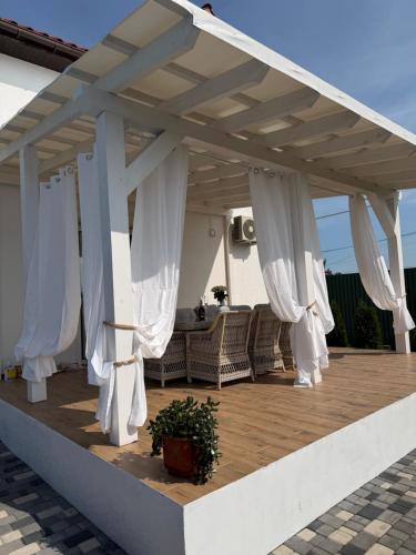 a pavilion with white curtains on a patio at Villa Menorca in Chornomorsk
