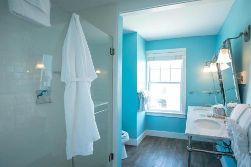 a blue bathroom with a sink and a mirror at The Tides Beach Club in Kennebunkport