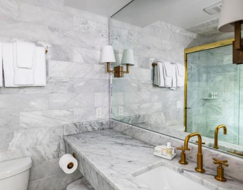 a white bathroom with a tub and a sink at Yachtsman Lodge & Marina in Kennebunkport