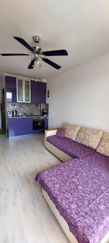 a bedroom with purple furniture and a ceiling fan at Апартамент ШАХОВ in Tŭnkovo