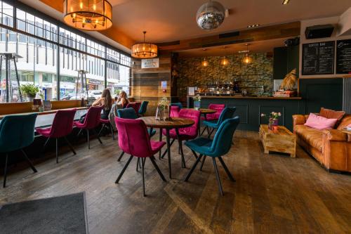 a restaurant with pink chairs and a table and a couch at The Loopy Shrew in Shrewsbury
