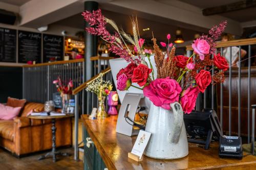 two vases filled with red roses on a table at The Loopy Shrew in Shrewsbury