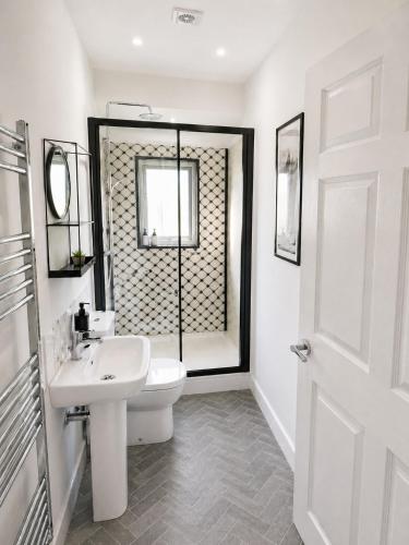 a white bathroom with a sink and a toilet at The Stables in Market Rasen