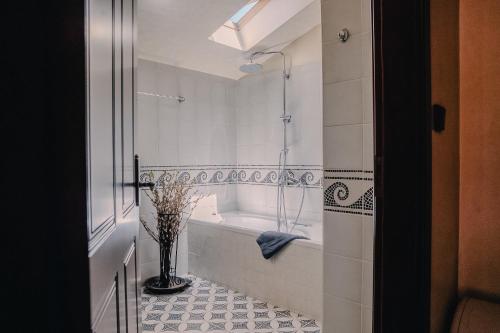 a bathroom with a tub and a vase on the floor at Palea Poli Boutique Hotel in Naousa