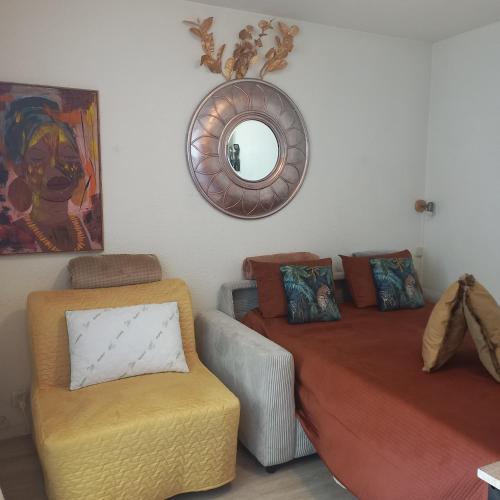 a bedroom with a bed and a chair and a mirror at Studio SAFARI in Luchon