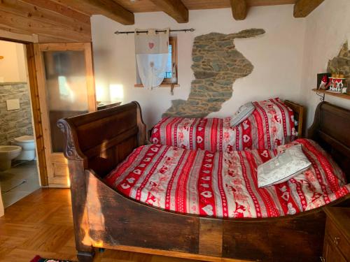 a bed in a room with a rock wall at El Torch di Long Elisa in San Garmano Chisone
