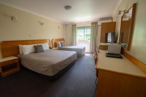 a hotel room with a bed and a television at Narellan Motor Inn in Narellan