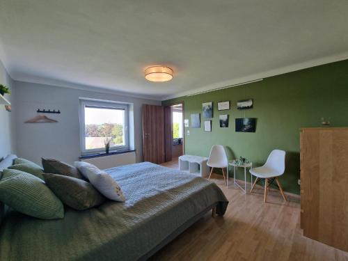 a bedroom with a bed and a table and chairs at Eiflia- Im Warchetal in Bullange