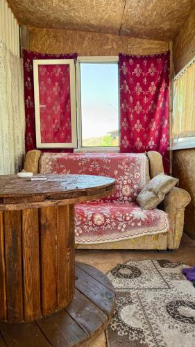 a living room with a couch and a table at House on the mountain in Ustʼ-Kamenogorsk