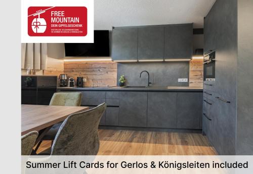 a kitchen with gray cabinets and a table with chairs at Apartment Gerlos 183 in Gerlos