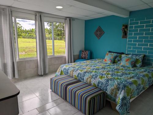 a blue bedroom with a bed and a window at La Bella Vista in Calarcá