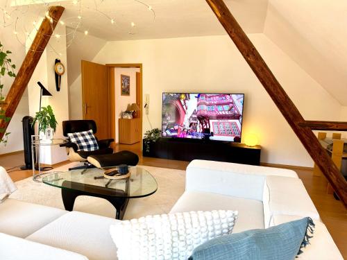 a living room with a white couch and a tv at Ferienhaus Burgblick am Hang in Bernkastel-Kues