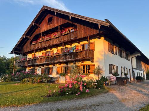 a large wooden house with flowers in front of it at Ferienwohnungen Heissbauer in Wackersberg