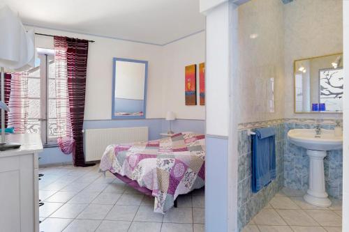 a bedroom with a bed and a sink at Le Clos Mazerolles in Cruzy