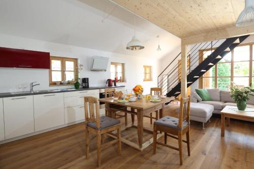 a kitchen and living room with a table and chairs at Designerwohnungen "Beim Schmied" in Chiemseenähe in Traunreut