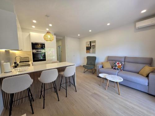 a kitchen and living room with a couch and a table at Apartamentos Mar-Sol Villas in Vilamoura
