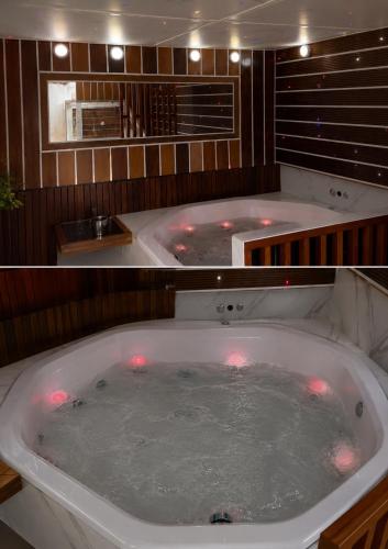 a large bath tub with red lights in a bathroom at Mała Anglia Deluxe Rooms & SPA in Sopot