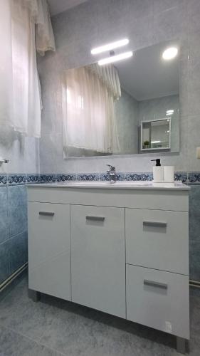 a white bathroom with a sink and a mirror at La casa de Hio in Hio
