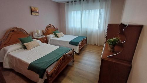 a hotel room with two beds and a window at La casa de Hio in Hio