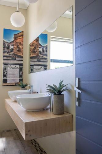 a bathroom with two sinks and a mirror at Stay At Friends in Bettyʼs Bay
