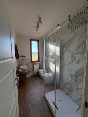 a bathroom with a glass shower and a toilet at Cindy Cottage Holiday Home in Giuncarico