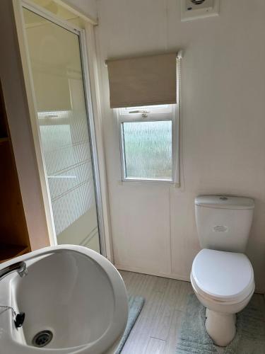 a bathroom with a tub and a toilet and a sink at Cosalt Sea View 18 in Ardentinny