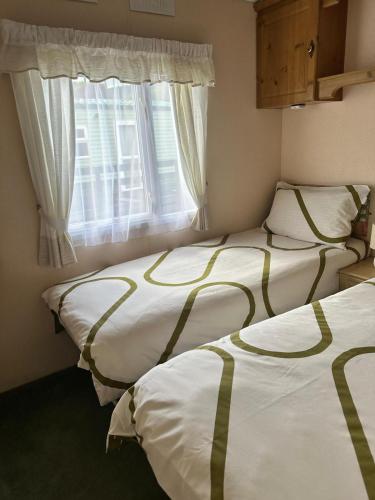 two beds in a room with a window at Cosalt Sea View 18 in Ardentinny