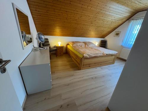a bedroom with a bed and a wooden ceiling at Corinnas Ferienwohnung in Büdingen
