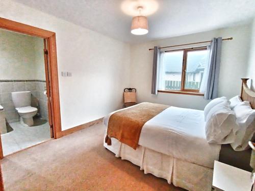 a bedroom with a bed and a bathroom with a shower at Golf View, Cruden Bay in Cruden Bay