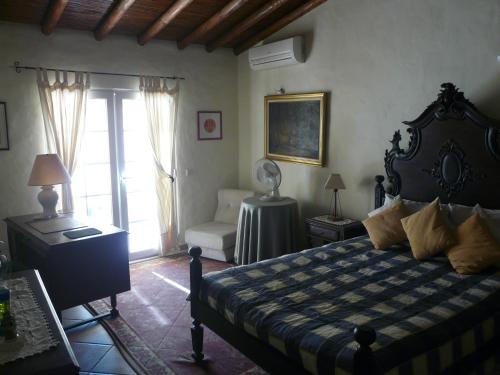 a bedroom with a bed and a chair and a window at Casa do Castelão in Loulé
