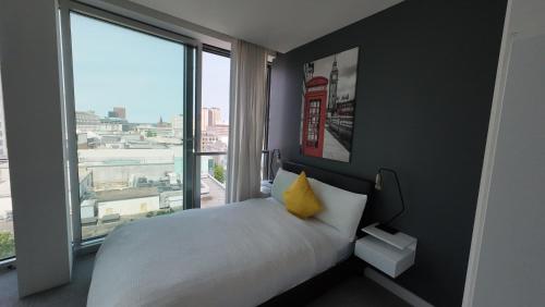 a bedroom with a bed with a phone booth on the wall at Nirankaar peace 1bhk in Birmingham