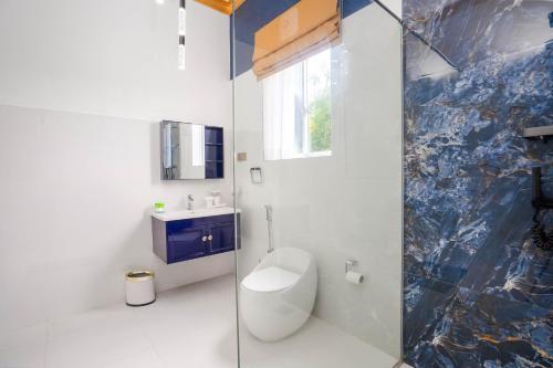 a bathroom with a toilet and a glass shower at Monara Villa in Dharga Town