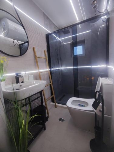 a bathroom with a toilet and a sink and a shower at Апартамент Skyline in Yambol