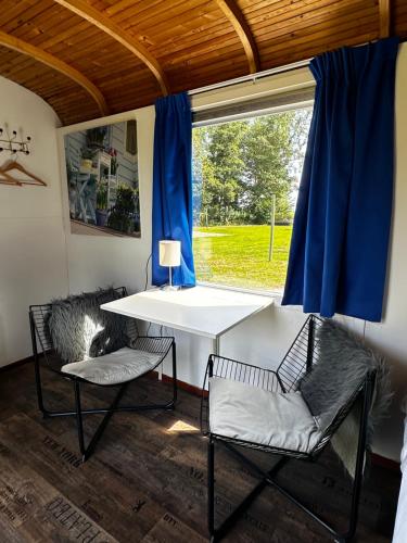 a table and two chairs in a room with a window at Het Huis van Bewustzijn in Limmen