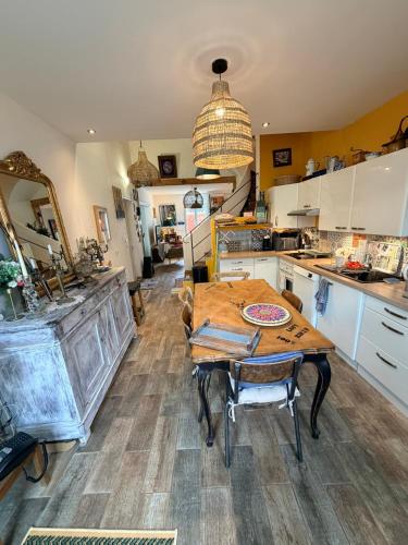 a kitchen with a wooden table and a dining room at La Vigneronne in Maureilhan-et-Raméjan