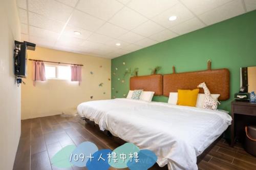 a bedroom with a large bed with green walls at 蒲Going旅宿 in Xiaoliuqiu