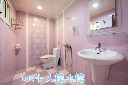 a pink bathroom with a sink and a toilet at 蒲Going旅宿 in Xiaoliuqiu