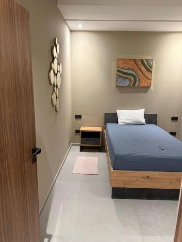 a bedroom with a blue bed and a wooden door at VILLA Noor Atlas in Aghmat