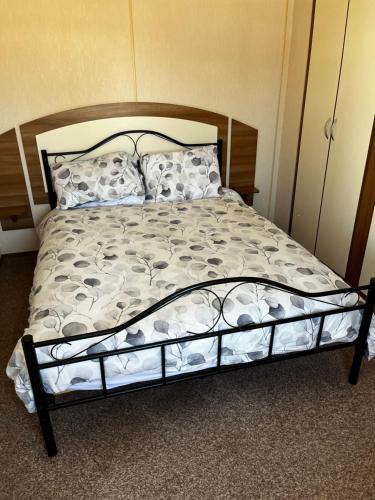 a bedroom with a bed with a wooden frame at California cliffs caravan in Great Yarmouth