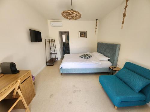 a bedroom with a bed and a blue chair at Eunoia in Vama Veche