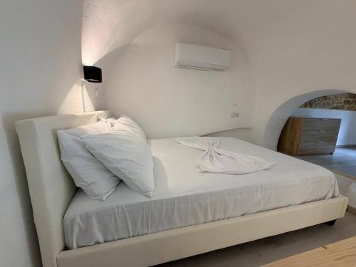 a white bed with white sheets and pillows on it at Encanto Griego in Chios