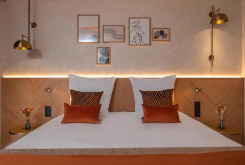 a white bed with four pillows on top of it at Hôtel Burdigala by Inwood Hotels in Bordeaux