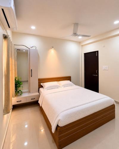 a bedroom with a large bed and a mirror at Veechi Retreat in Secunderabad
